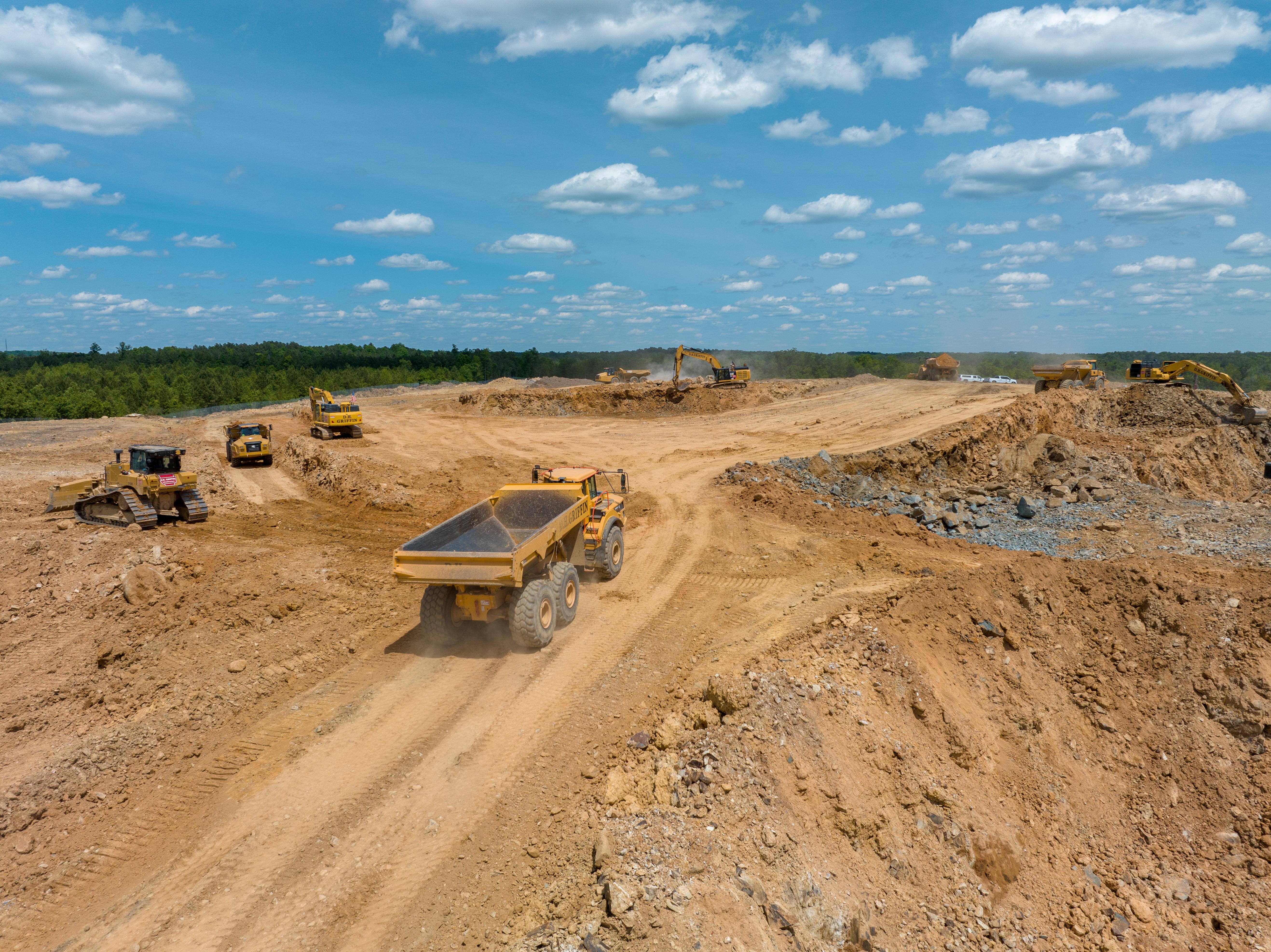 line of excavators at construction site